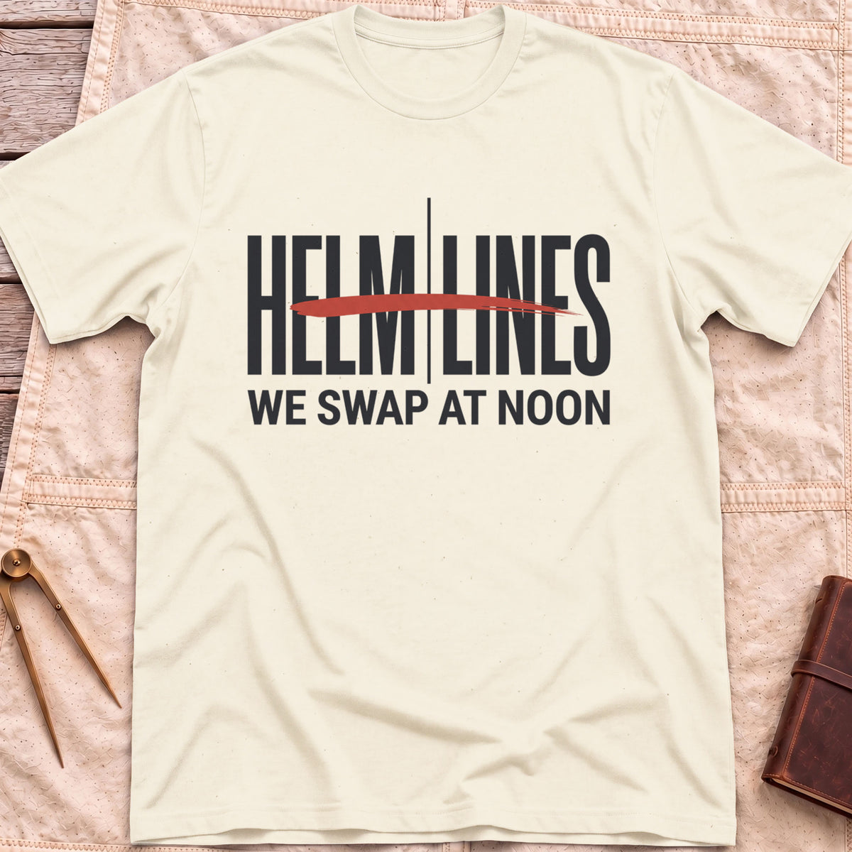 Front view of the natural Swap at Noon T-Shirt with the words Helm and Lines split by a vertical line and a red brushstroke, above We Swap at Noon.