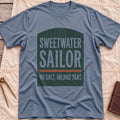 Front view of the heather indigo Sweetwater Sailor T-Shirt with an arched green panel reading Sweetwater Sailor above No Salt, Inland Seas.