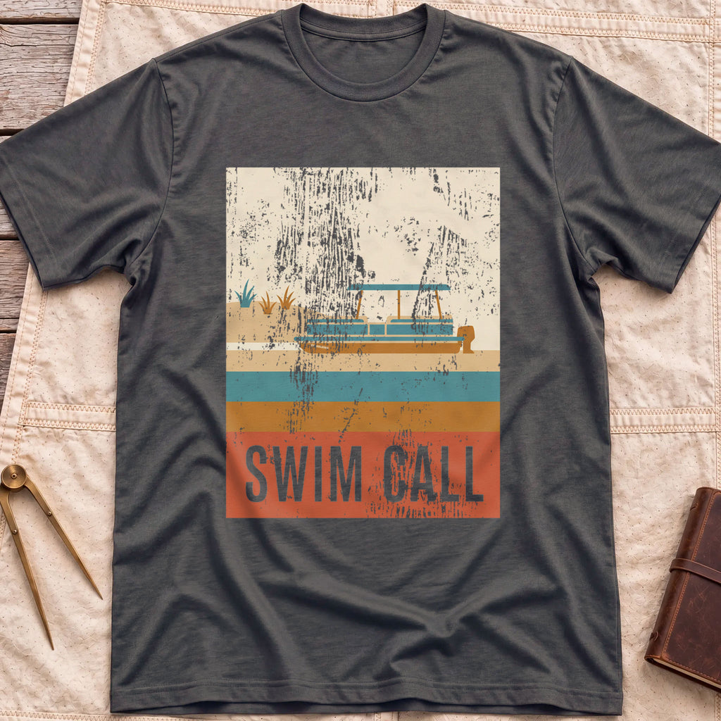 Front view of the dark heather Swim Call T-Shirt with a distressed retro poster of a canopied pontoon boat over striped water above the words Swim Call.