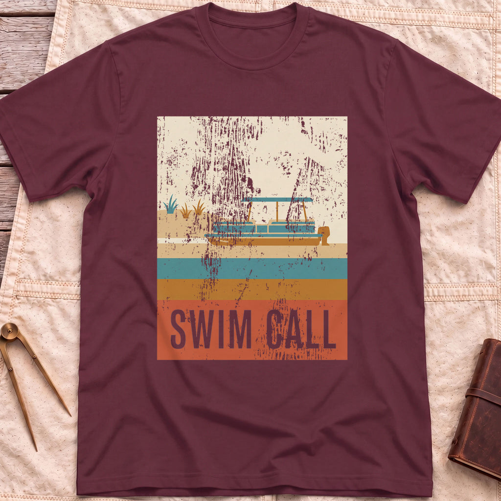 Front view of the maroon Swim Call T-Shirt with a distressed retro poster of a canopied pontoon boat over striped water above the words Swim Call.