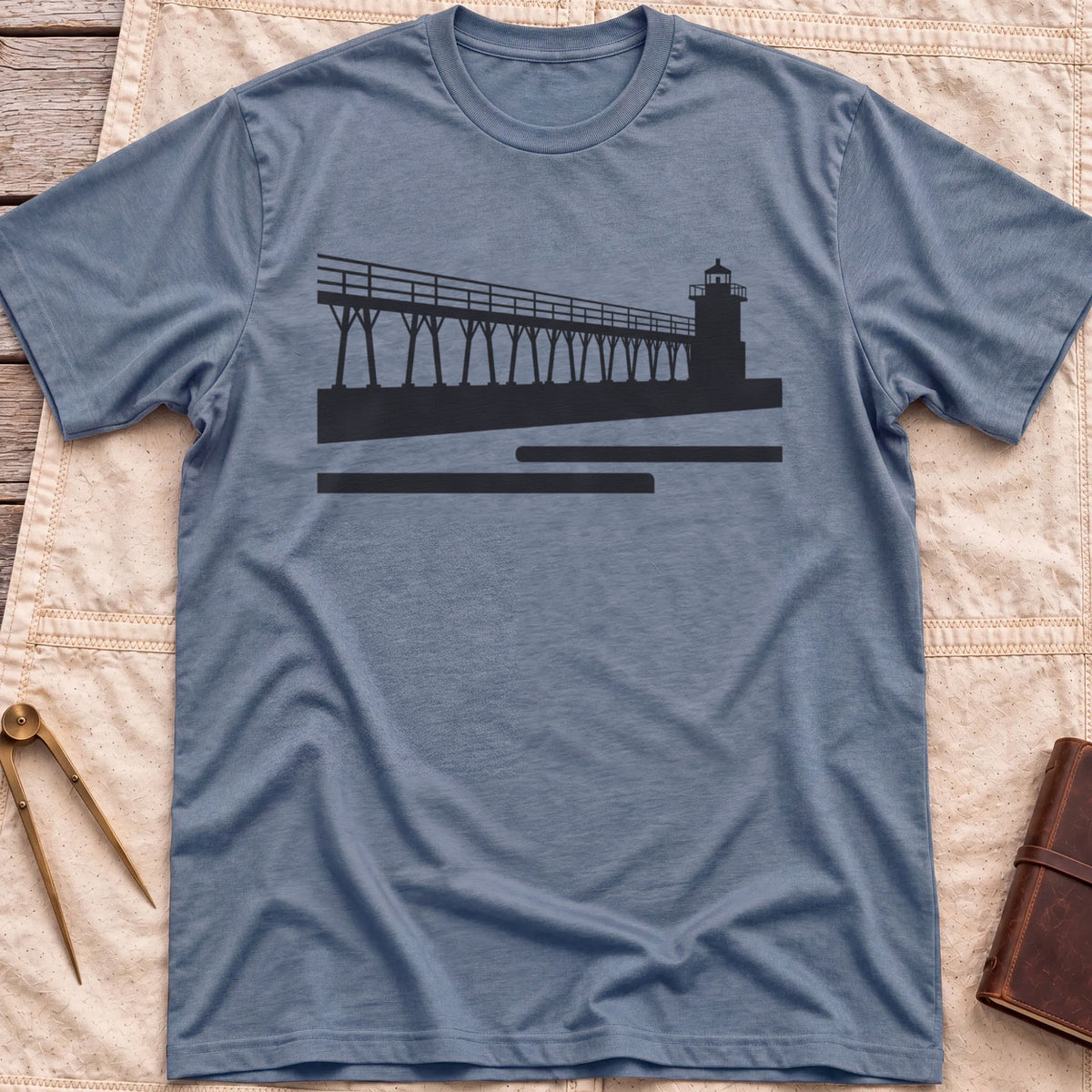 Front view of the heather indigo The Catwalk T-Shirt with a silhouette of a raised walkway running along a pier to a lighthouse.