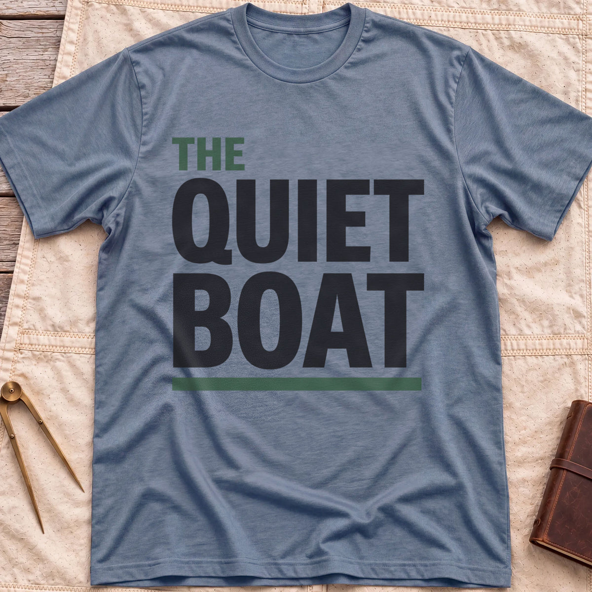 Front view of the heather indigo The Quiet Boat T-Shirt with the words The Quiet Boat in heavy capitals above a green underline.