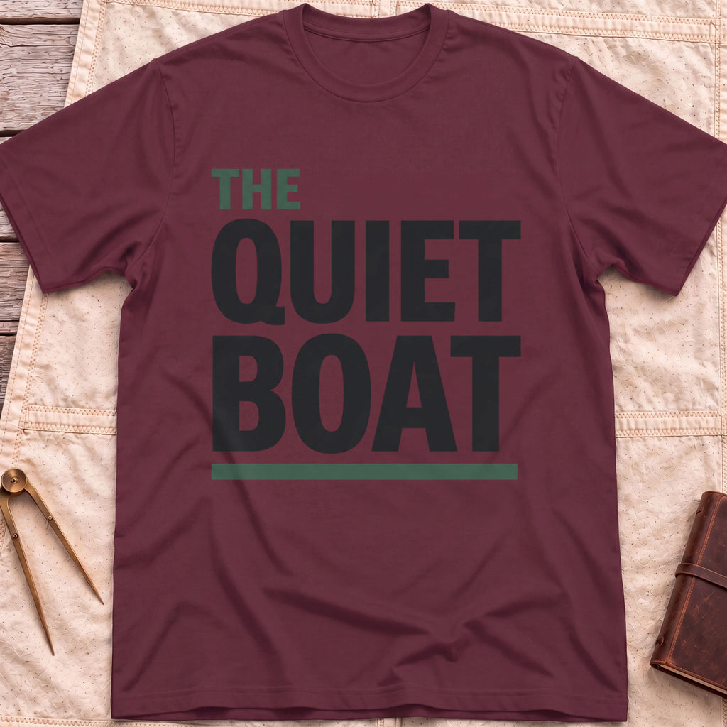 Front view of the maroon The Quiet Boat T-Shirt with the words The Quiet Boat in heavy capitals above a green underline.