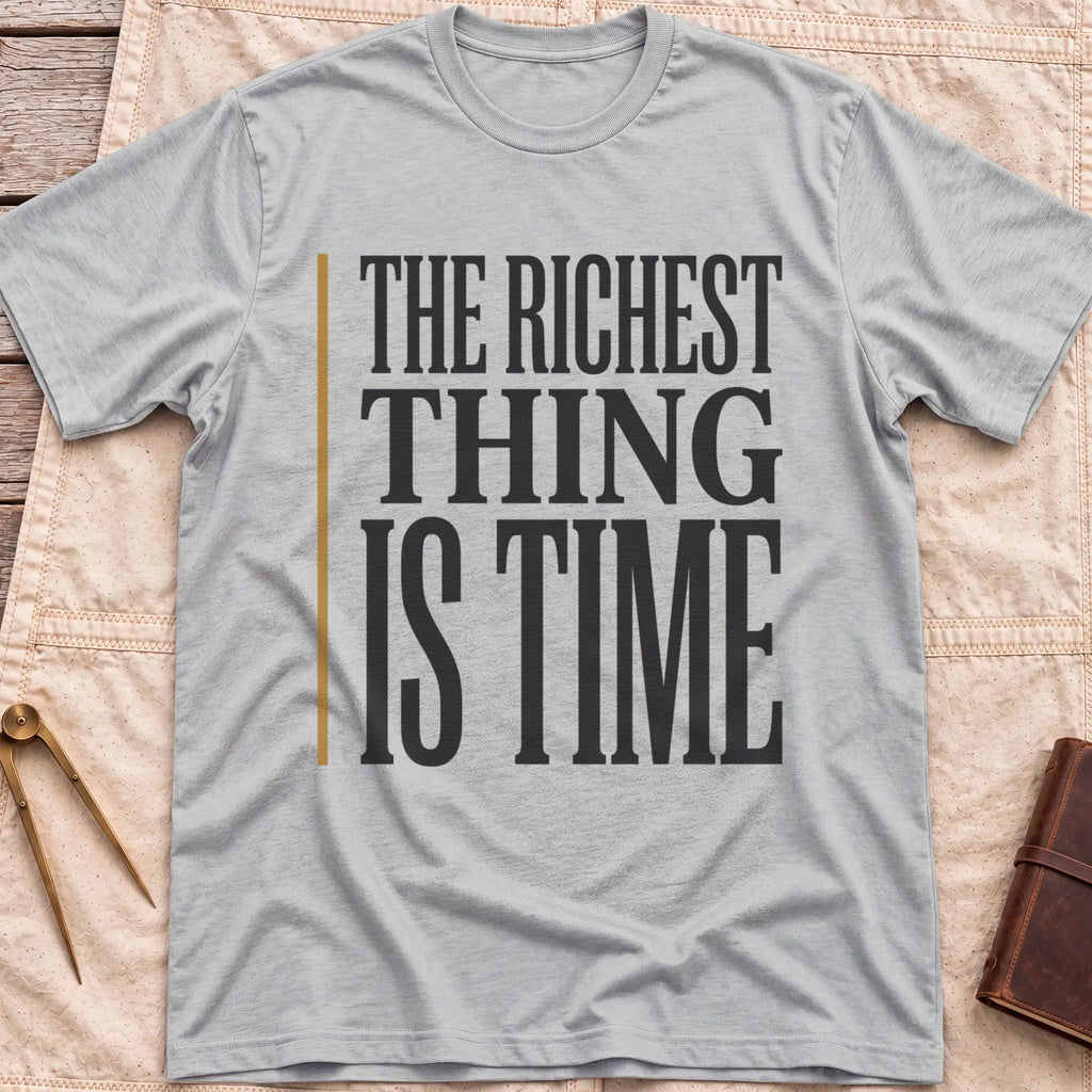 Front view of the sport grey The Richest Thing T-Shirt with the words The Richest Thing Is Time in tall condensed type beside a tan line.