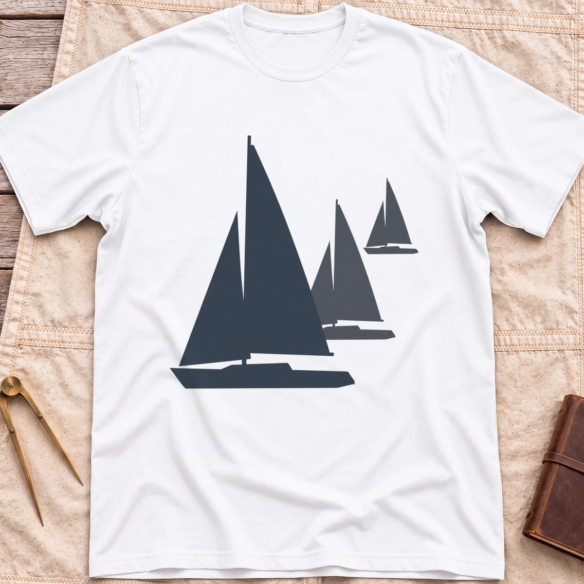Front view of the white Three Sails T-Shirt with silhouettes of three sailboats in decreasing sizes.