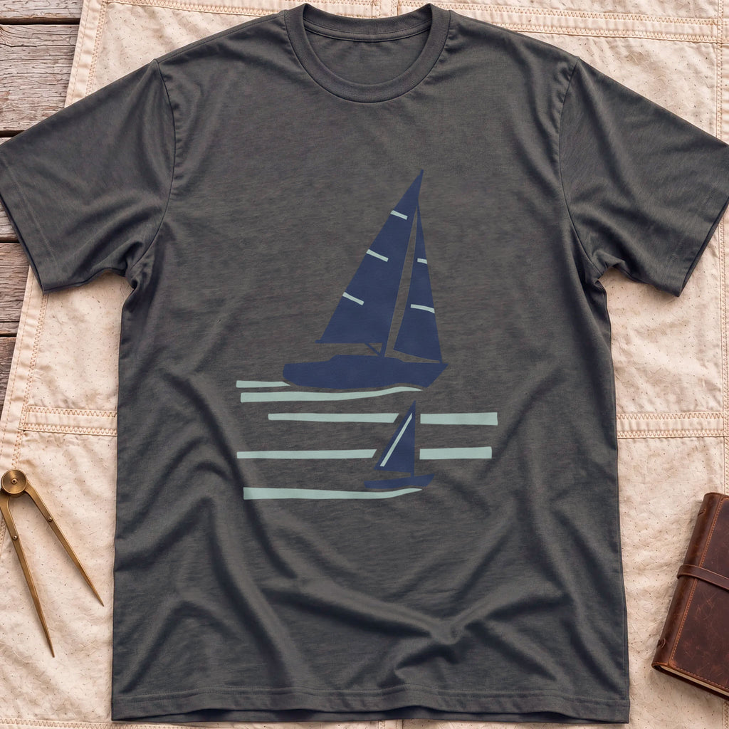 Front view of the dark heather Two Wake T-Shirt with a large and a small sailboat over pale wake lines.