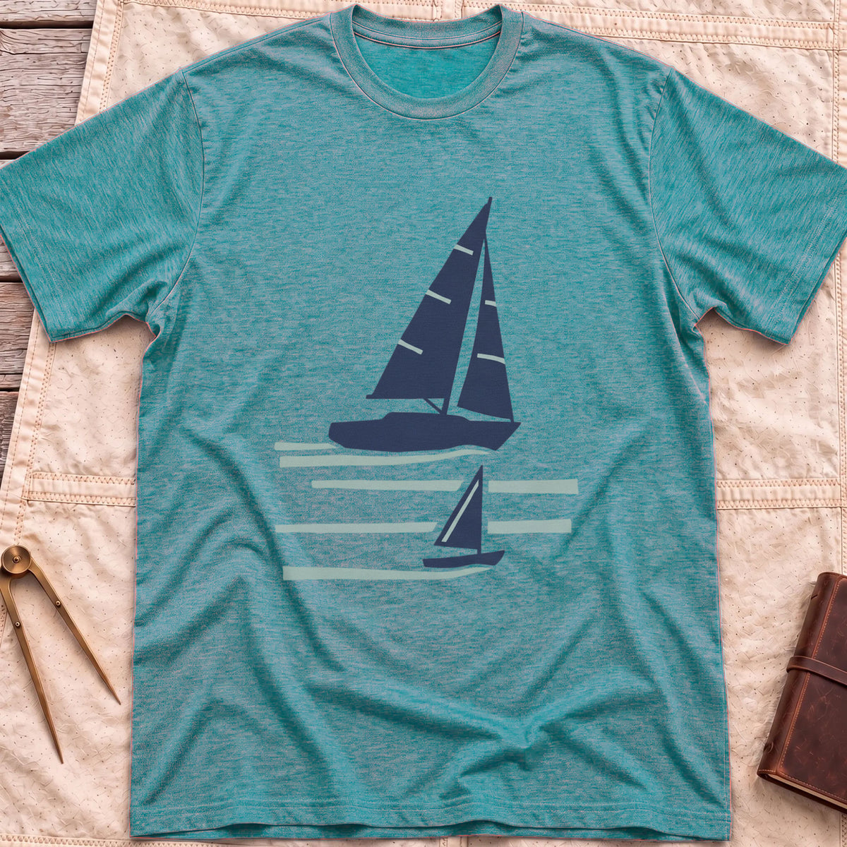 Front view of the heather galapagos blue Two Wake T-Shirt with a large and a small sailboat over pale wake lines.