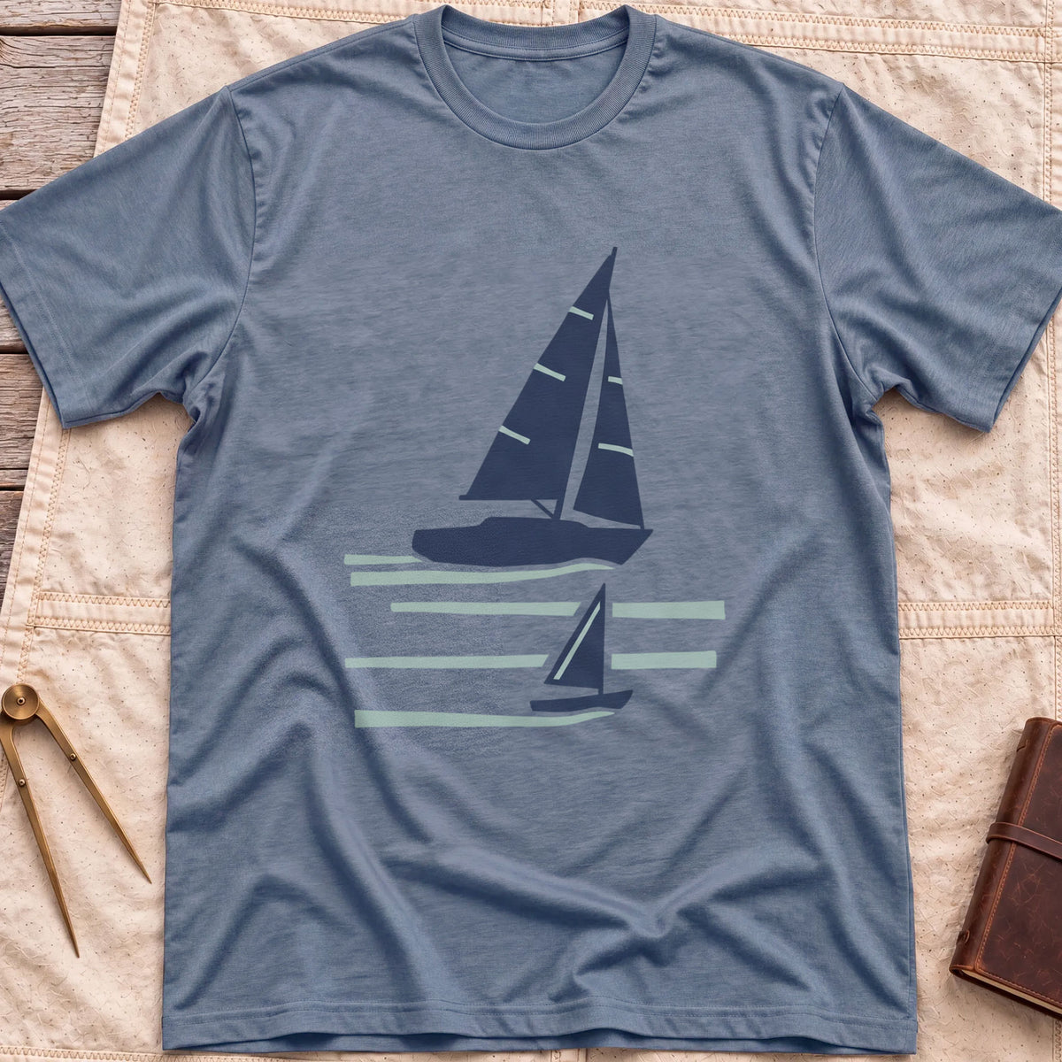 Front view of the heather indigo Two Wake T-Shirt with a large and a small sailboat over pale wake lines.