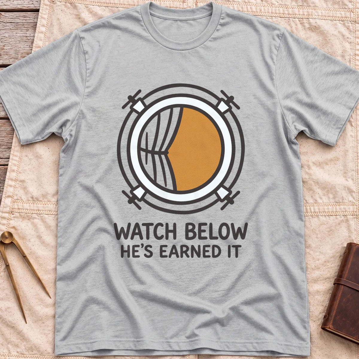 Front view of the sport grey Watch Below T-Shirt with a round porthole and a half-drawn curtain above the words He's Earned It.