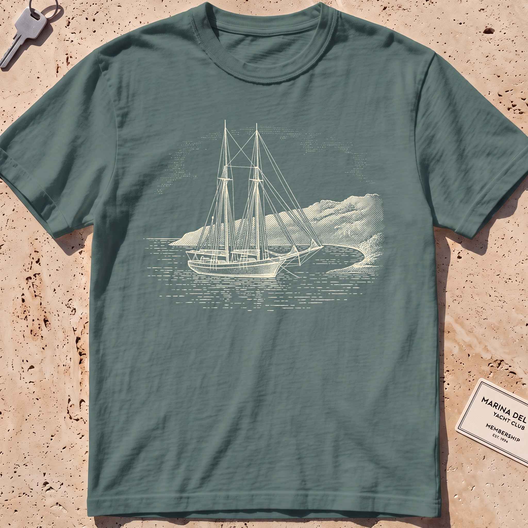 blue spruce heavyweight tee with an etched schooner moored in a cove graphic.