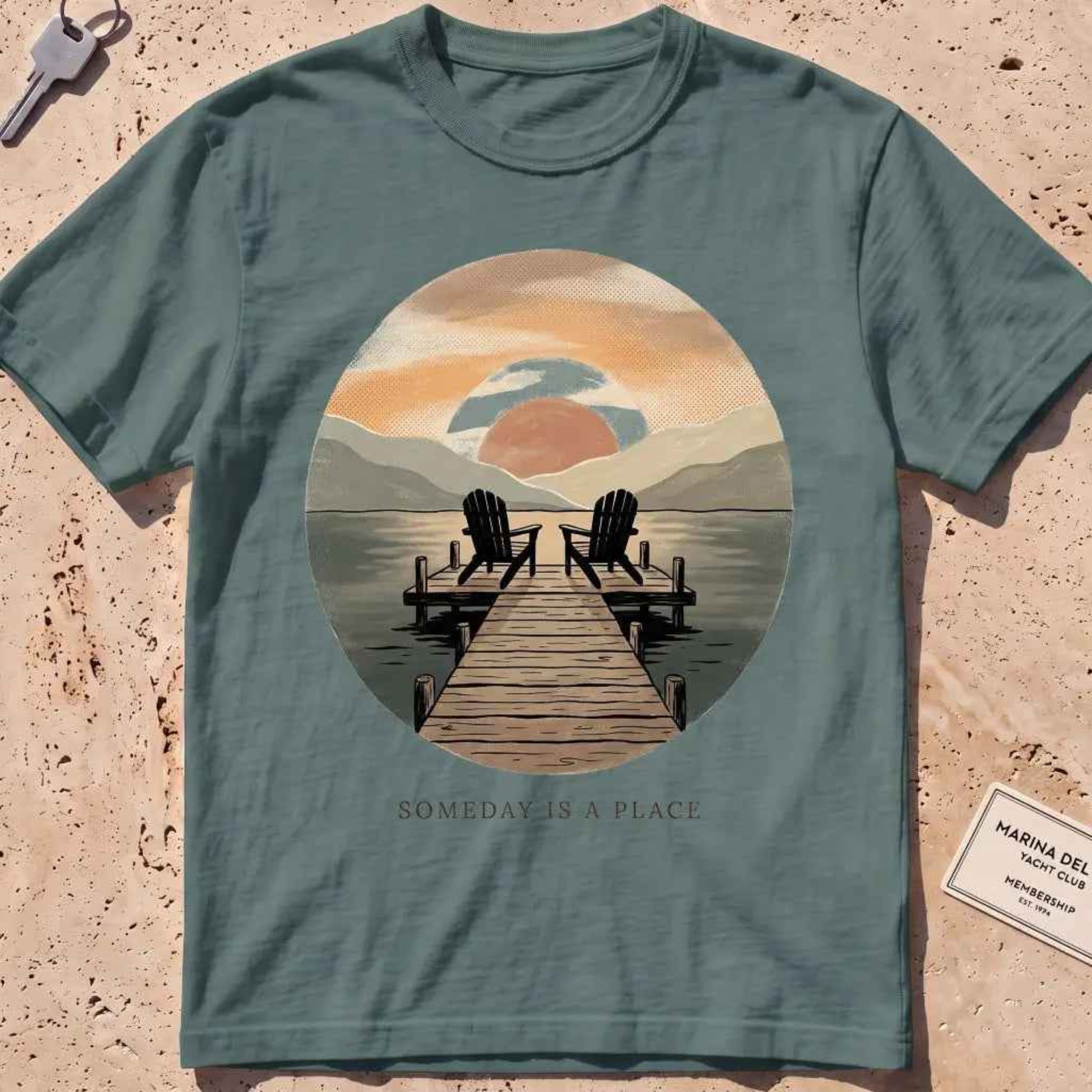 blue spruce heavyweight tee with a warm dock-at-dusk "Someday Is a Place" scene.
