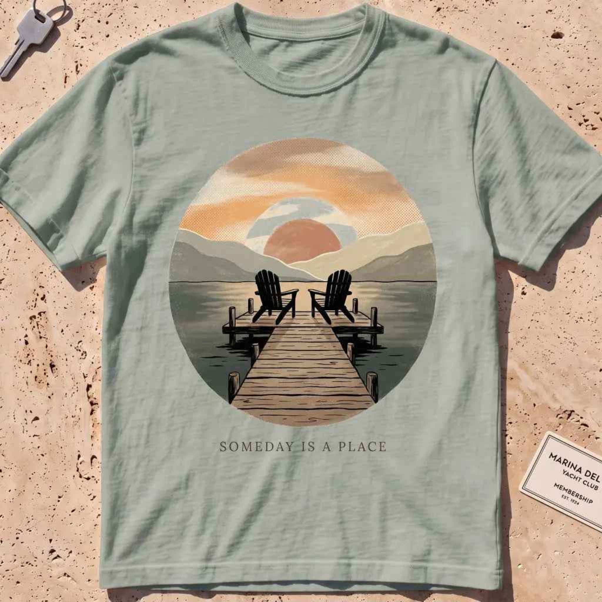 bay heavyweight tee with a warm dock-at-dusk "Someday Is a Place" scene.