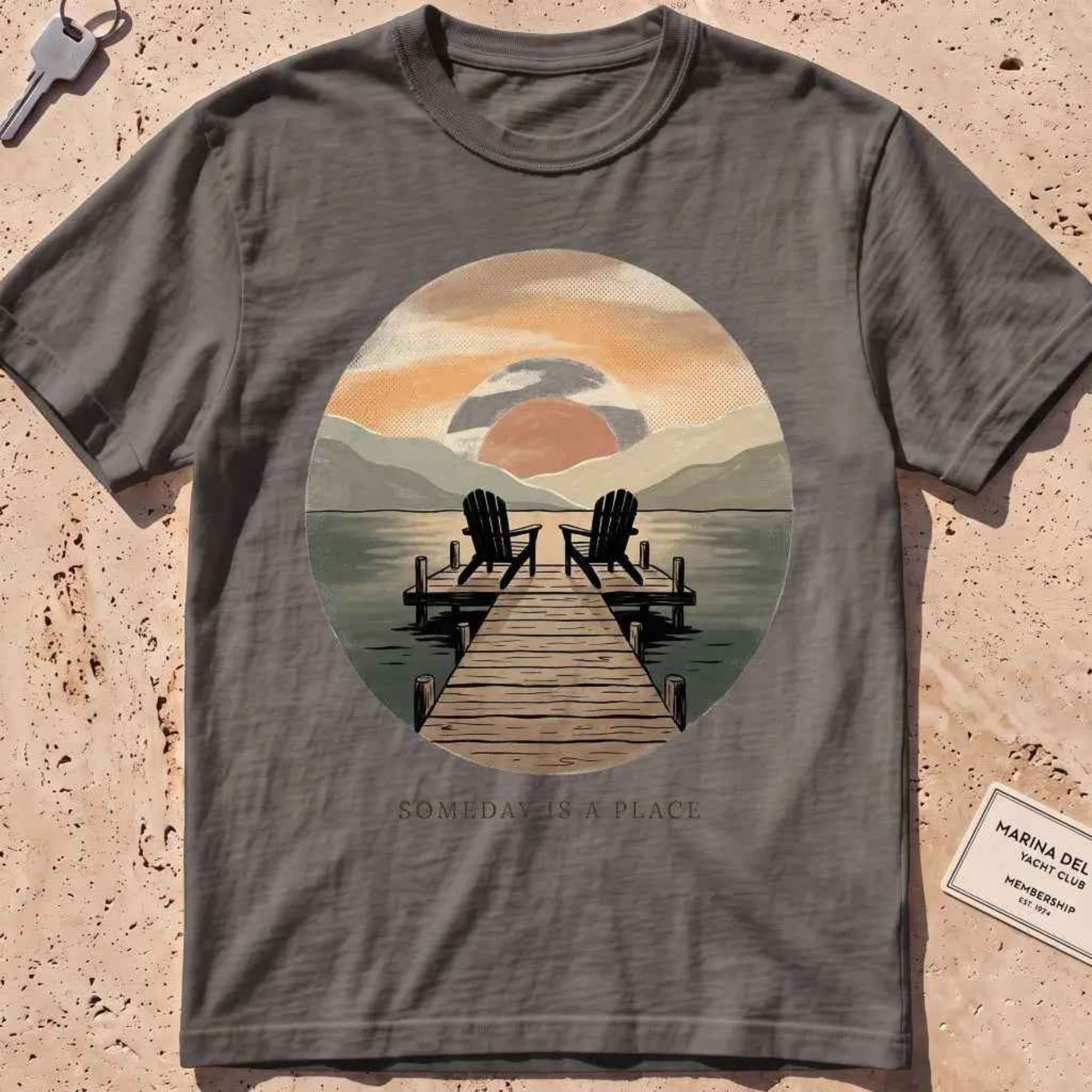 pepper heavyweight tee with a warm dock-at-dusk "Someday Is a Place" scene.