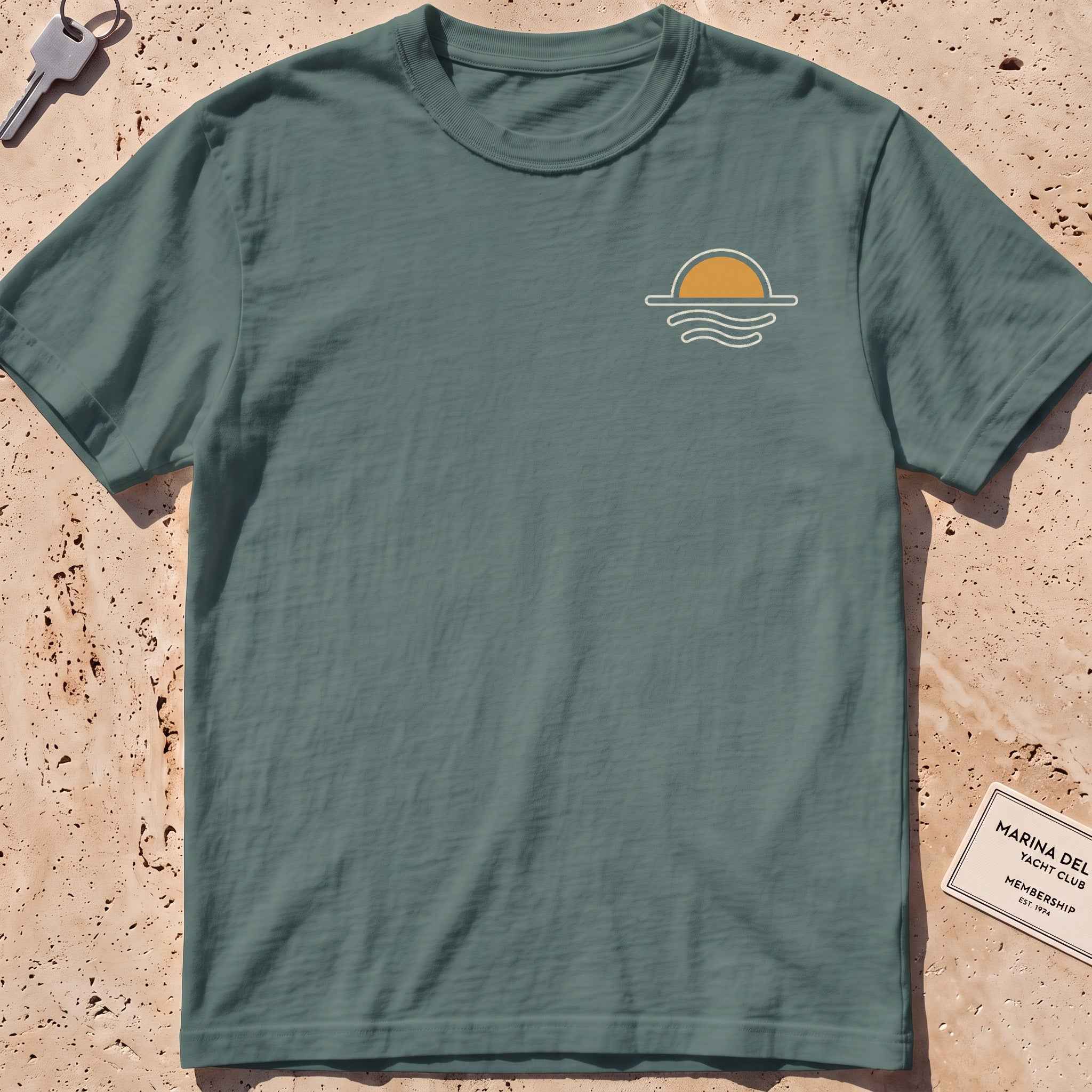 blue spruce heavyweight tee with a sun-and-waves crest graphic.