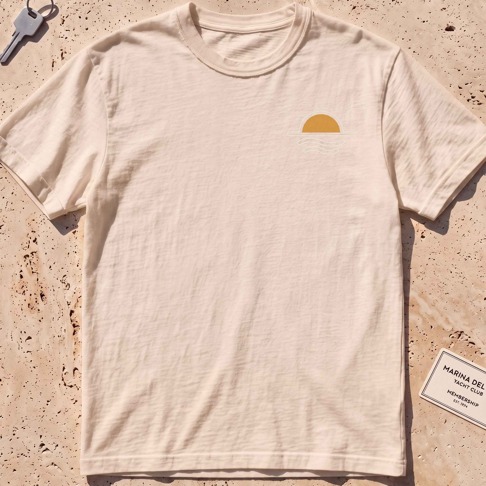 ivory heavyweight tee with a sun-and-waves crest graphic.