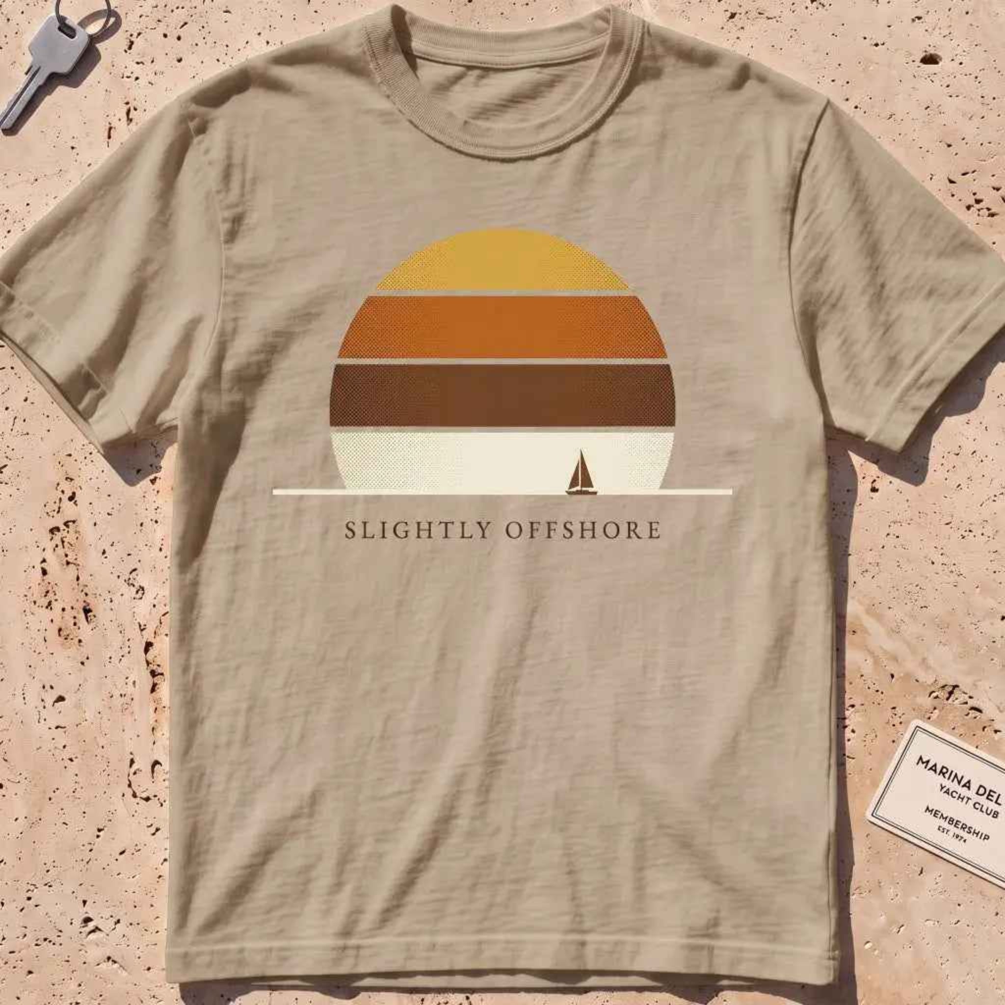 khaki heavyweight tee with a striped sun disc and tiny sailboat graphic.