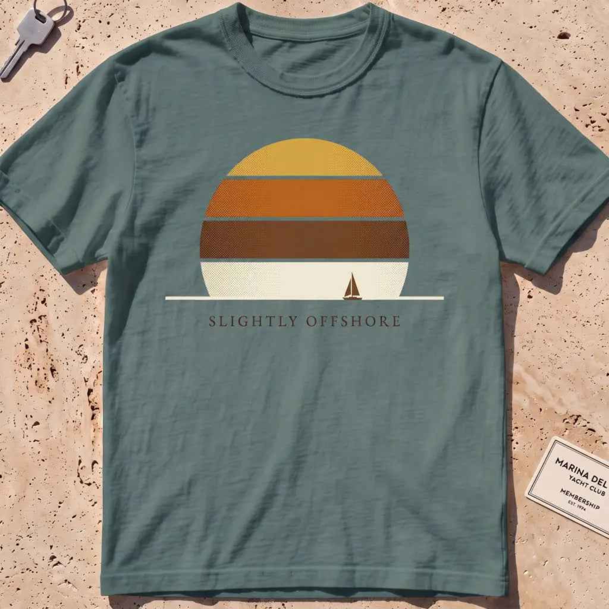 blue spruce heavyweight tee with a striped sun disc and tiny sailboat graphic.