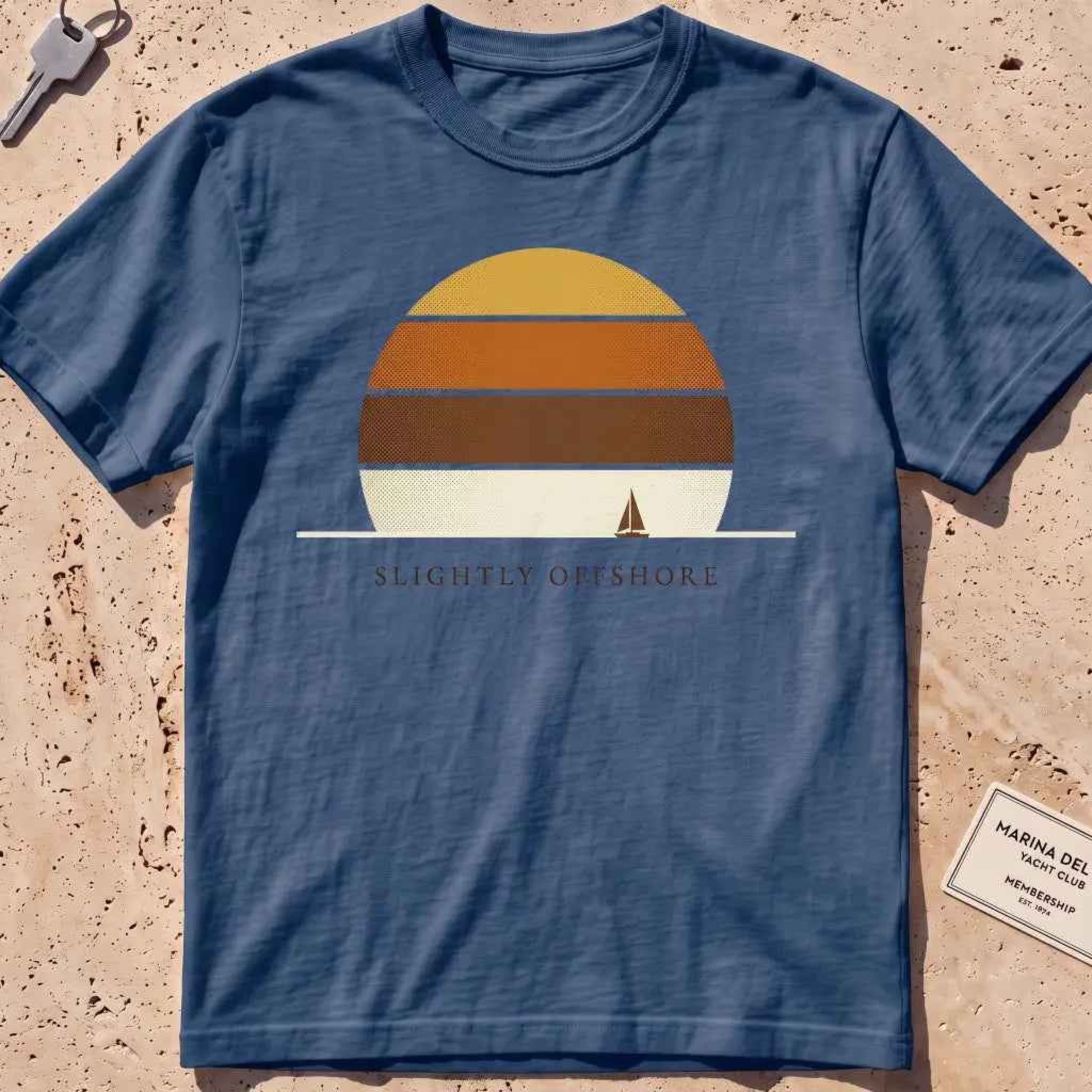 midnight heavyweight tee with a striped sun disc and tiny sailboat graphic.