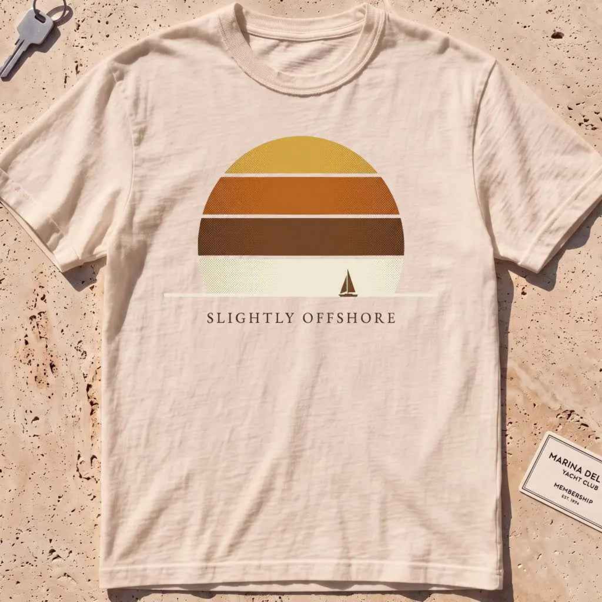 ivory heavyweight tee with a striped sun disc and tiny sailboat graphic.