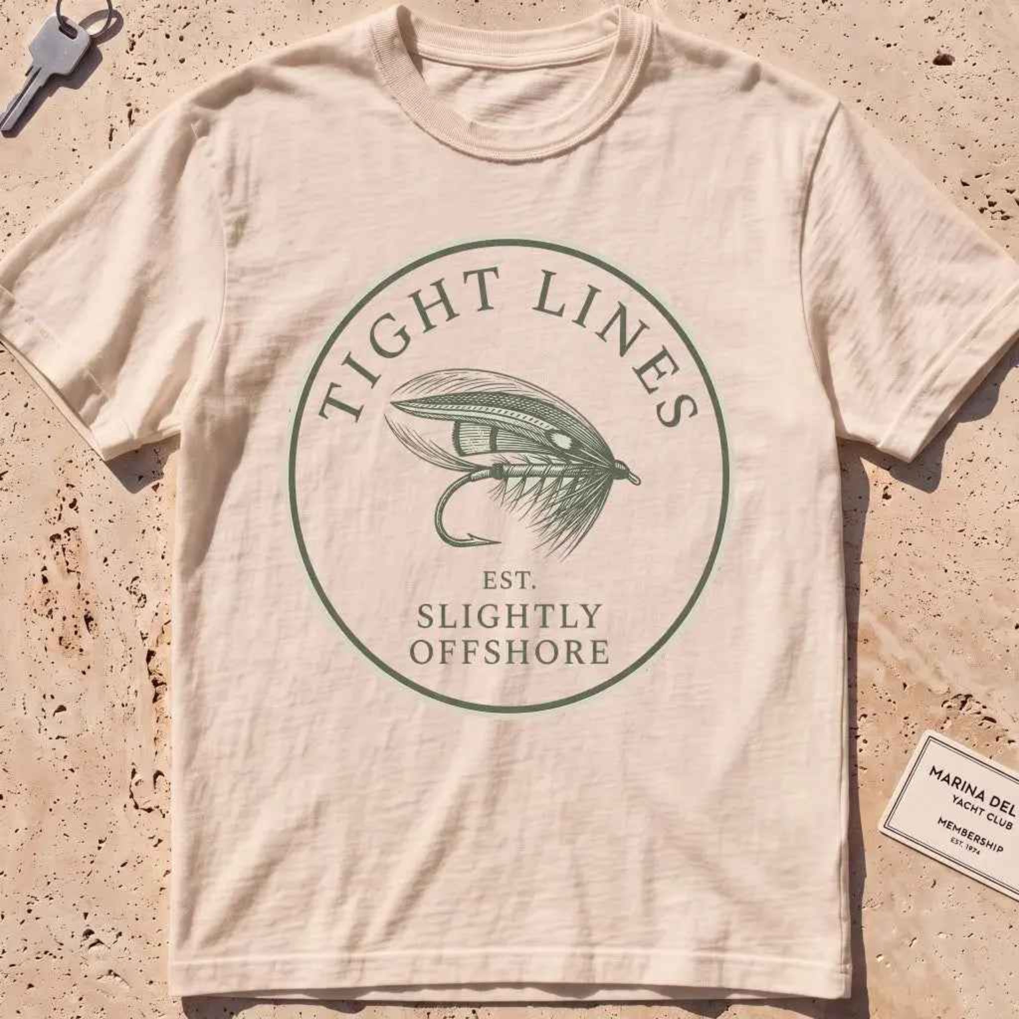 ivory heavyweight tee with an engraved "Tight Lines" fly-fishing crest.