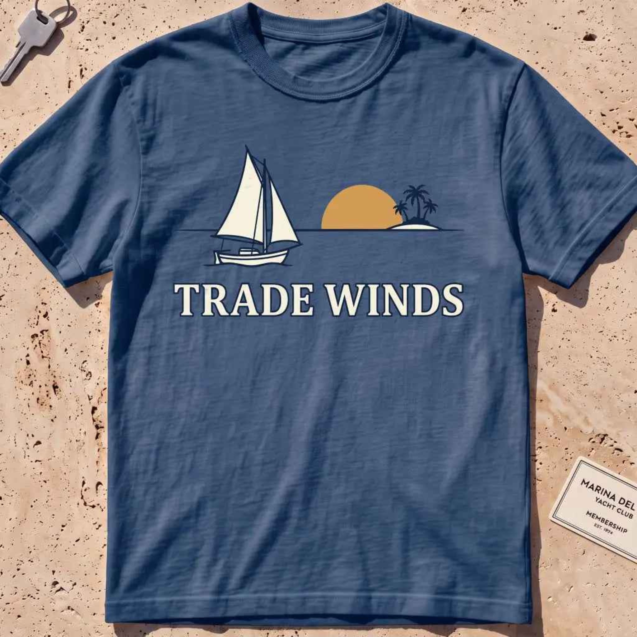midnight heavyweight tee with a sailboat, sun and palms "Trade Winds" graphic.
