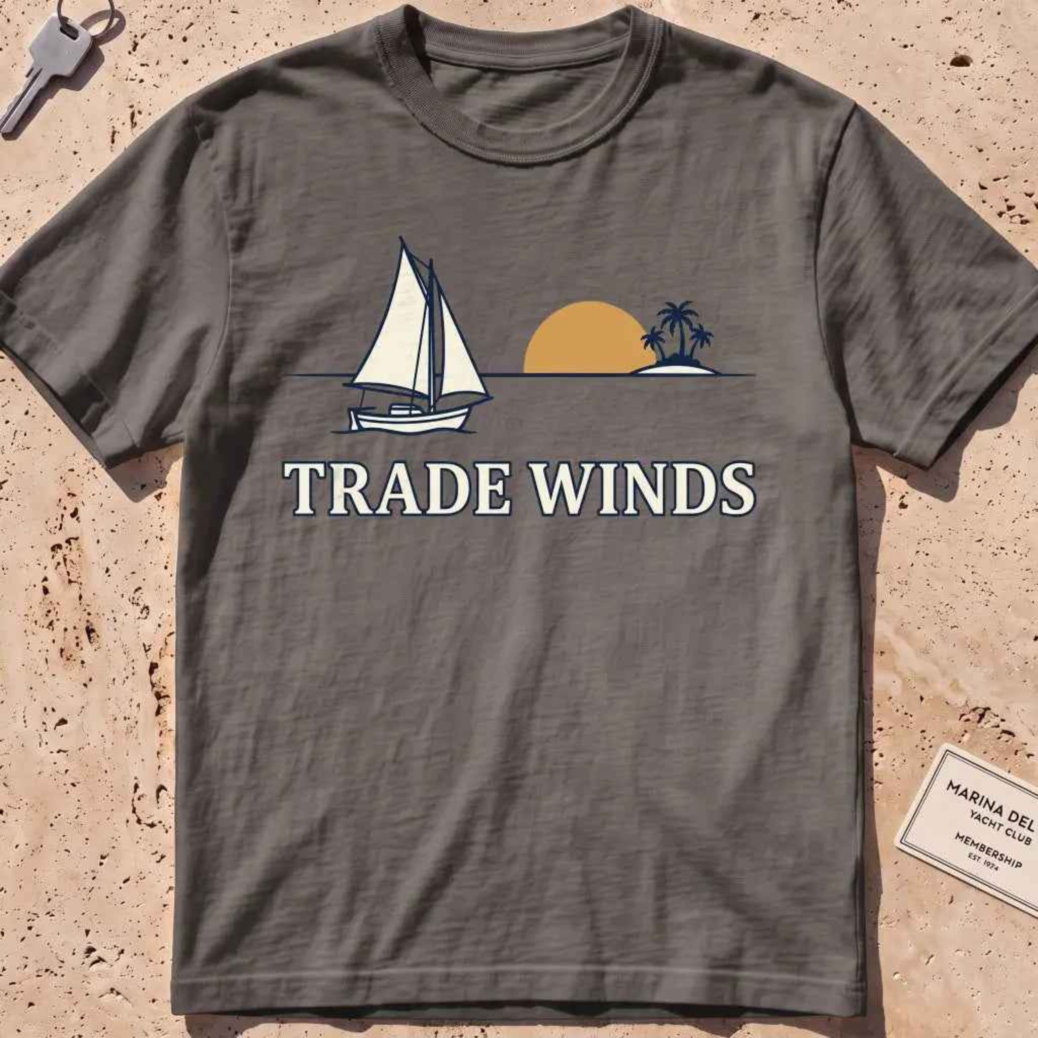 pepper heavyweight tee with a sailboat, sun and palms "Trade Winds" graphic.