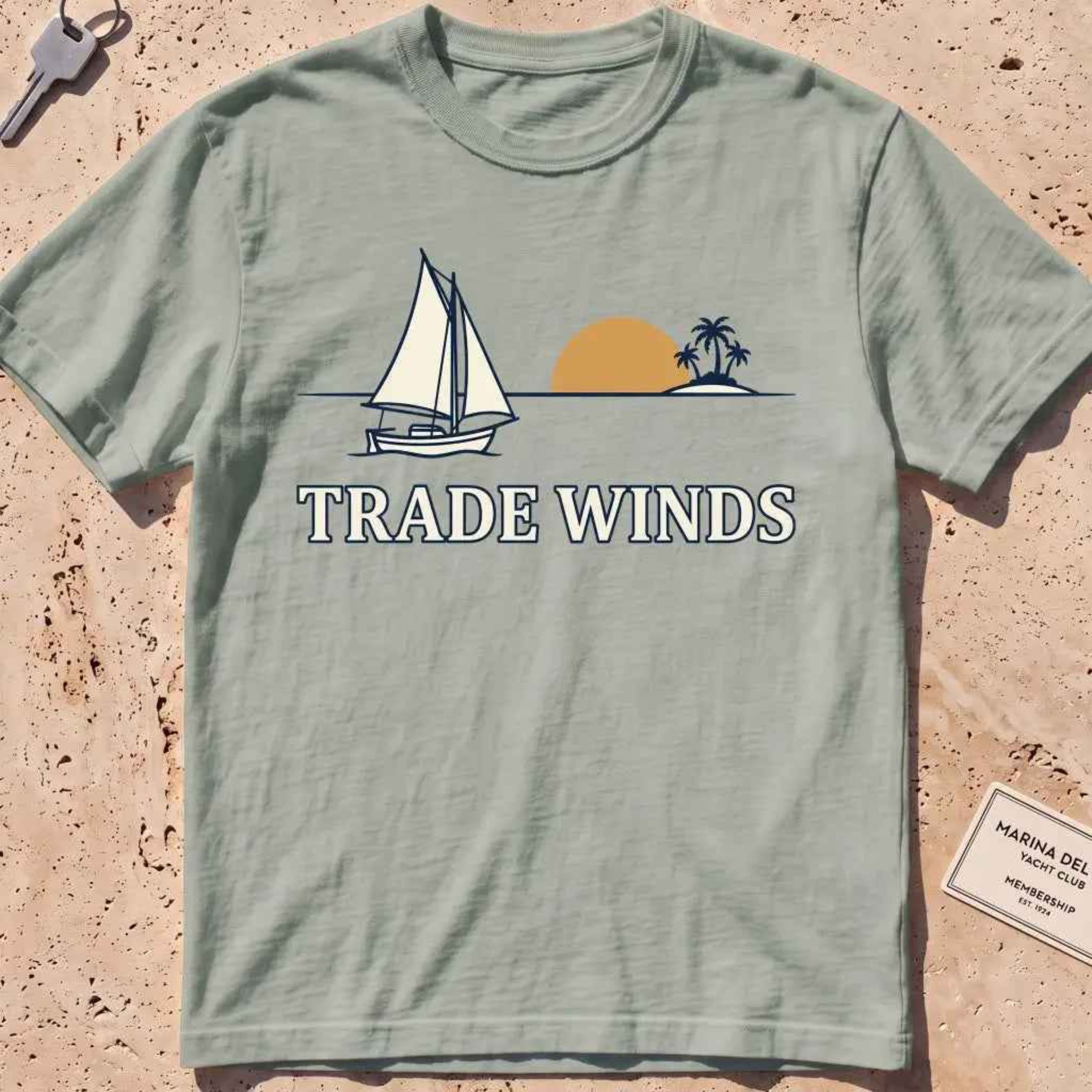 bay heavyweight tee with a sailboat, sun and palms "Trade Winds" graphic.