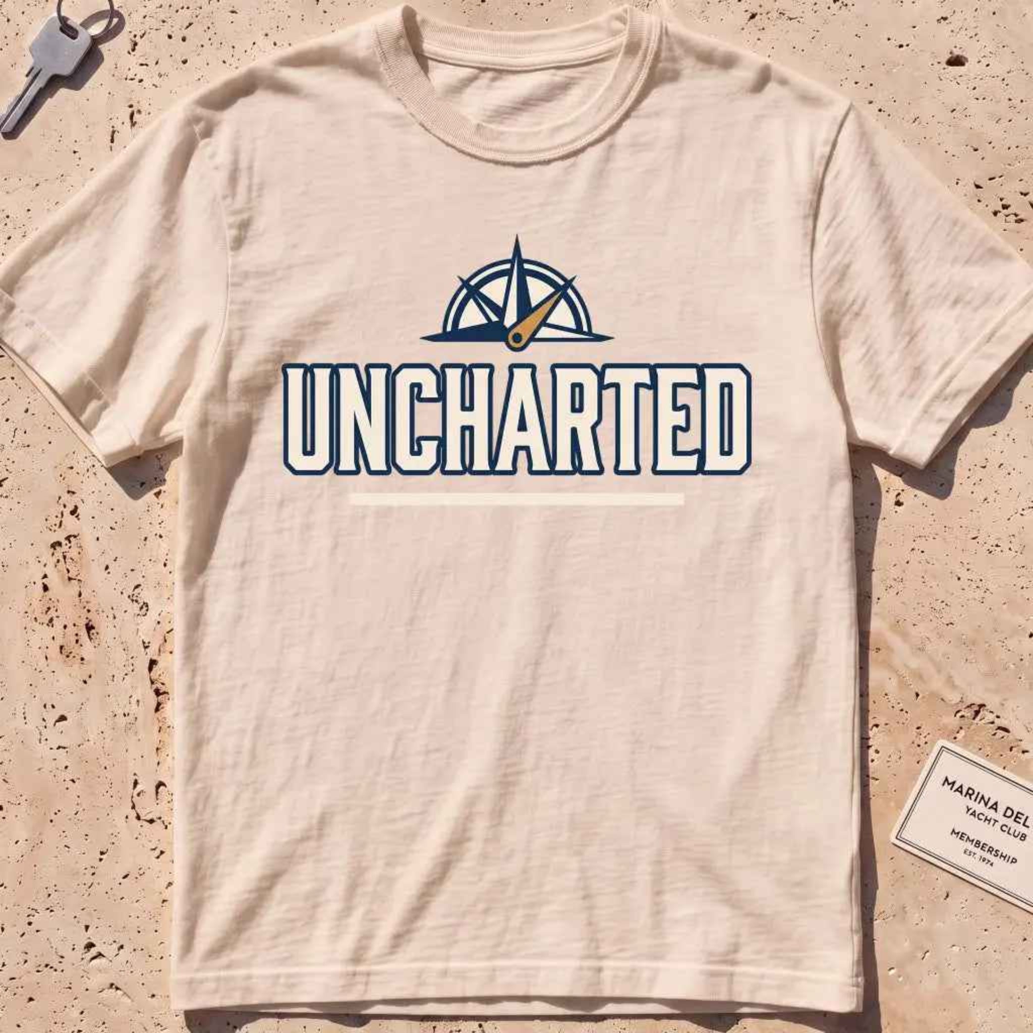 ivory heavyweight tee with a compass and bold "Uncharted" exploration type.